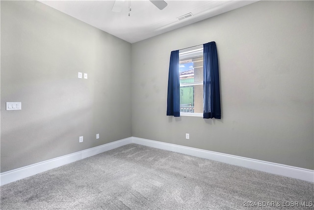 carpeted spare room with ceiling fan