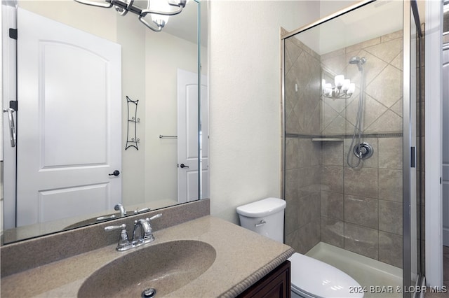 bathroom featuring a shower with door, vanity, and toilet