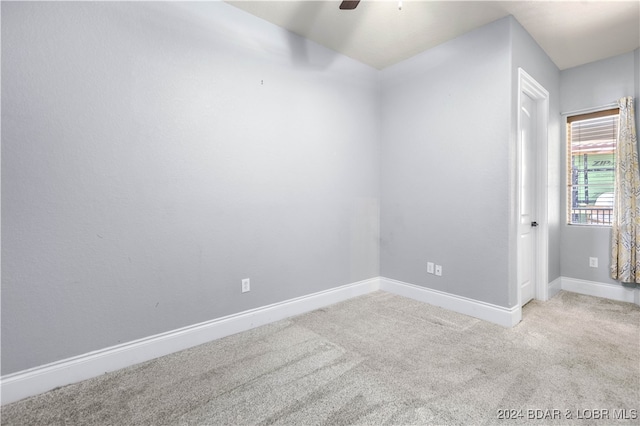 empty room featuring ceiling fan and light carpet