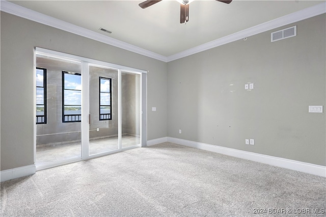 carpeted spare room with ceiling fan and ornamental molding