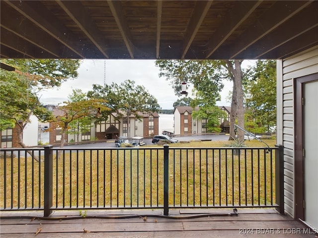 wooden terrace featuring a lawn