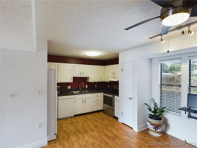 kitchen featuring a textured ceiling, light hardwood / wood-style flooring, sink, and white appliances