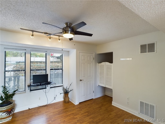 unfurnished living room featuring ceiling fan, a textured ceiling, and hardwood / wood-style floors