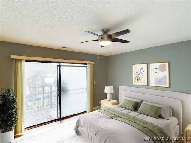 bedroom featuring access to outside, a textured ceiling, light wood-type flooring, and ceiling fan