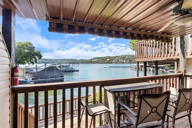 balcony featuring ceiling fan and a water view