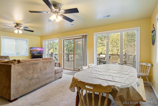 interior space with ceiling fan, light colored carpet, and plenty of natural light