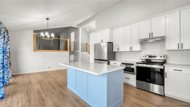 kitchen featuring a center island, a notable chandelier, white cabinets, vaulted ceiling, and appliances with stainless steel finishes