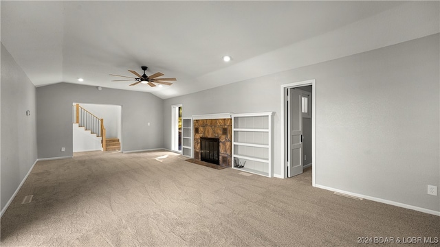 unfurnished living room with ceiling fan, light colored carpet, a fireplace, and vaulted ceiling