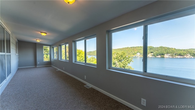 unfurnished sunroom featuring a healthy amount of sunlight and a water view