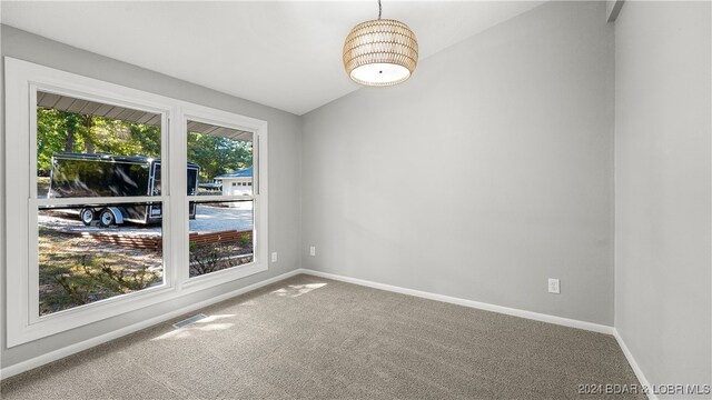 empty room with carpet and vaulted ceiling