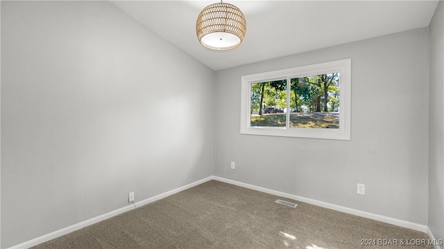 empty room featuring lofted ceiling and carpet floors