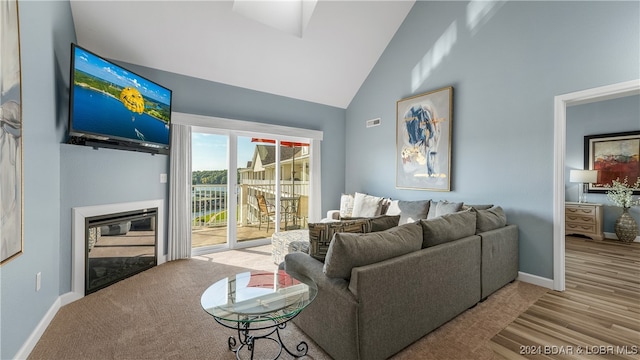 living room with high vaulted ceiling and light hardwood / wood-style floors