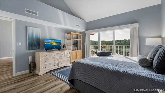 bedroom featuring light wood-type flooring, access to outside, and high vaulted ceiling