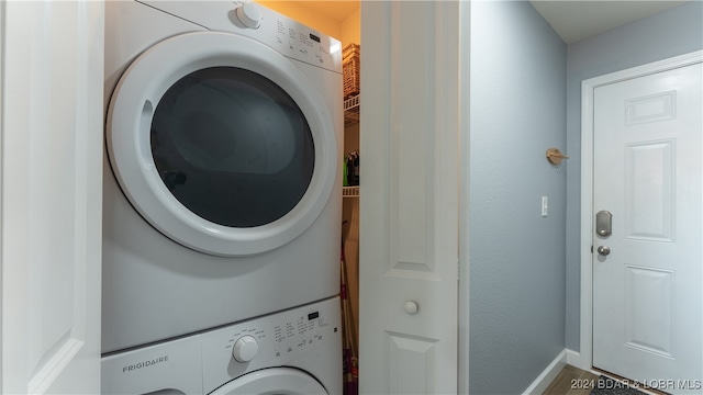 washroom featuring stacked washer / drying machine