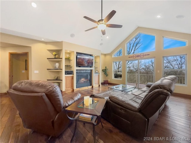 living room with high vaulted ceiling, built in features, ceiling fan, and dark wood-type flooring