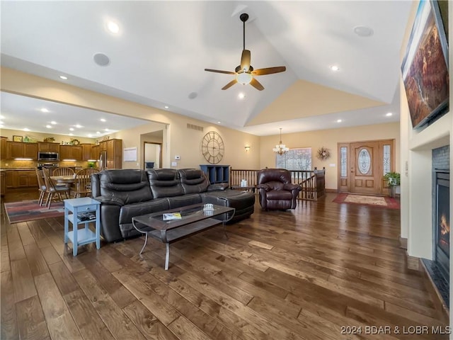 living room featuring ceiling fan with notable chandelier, dark hardwood / wood-style flooring, and high vaulted ceiling