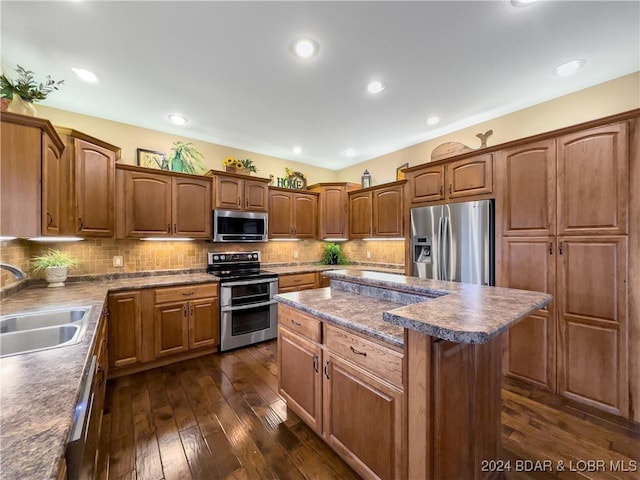 kitchen featuring sink, decorative backsplash, dark hardwood / wood-style floors, a kitchen island, and stainless steel appliances