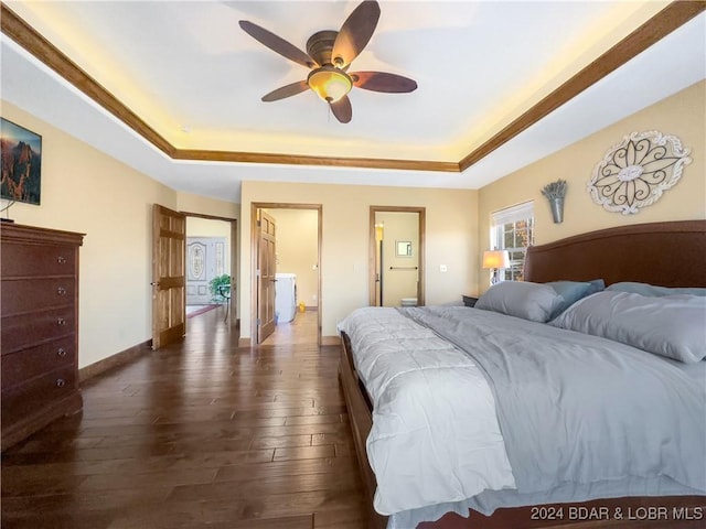 bedroom with a tray ceiling, ceiling fan, and dark wood-type flooring