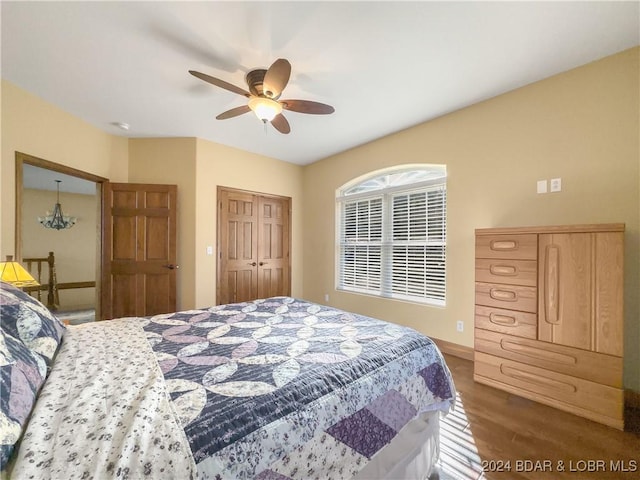 bedroom with dark hardwood / wood-style flooring, a closet, and ceiling fan