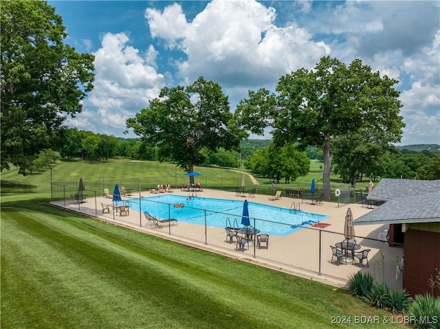 view of swimming pool featuring a patio and a lawn