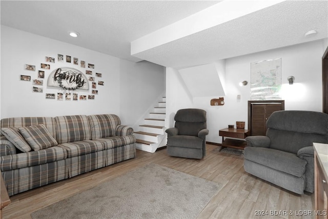 living room with a textured ceiling and light hardwood / wood-style flooring