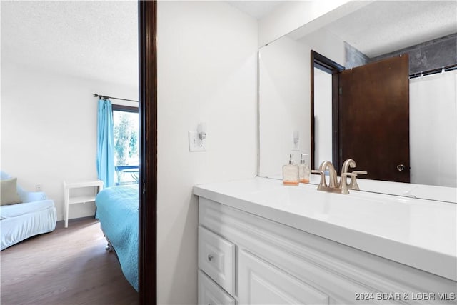 bathroom featuring vanity, wood-type flooring, and a textured ceiling