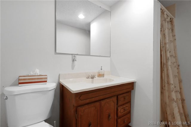 bathroom featuring vanity, toilet, and a textured ceiling