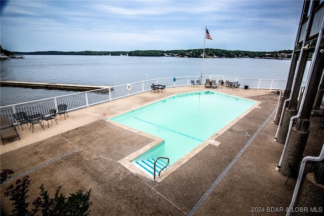 view of pool featuring a patio and a water view