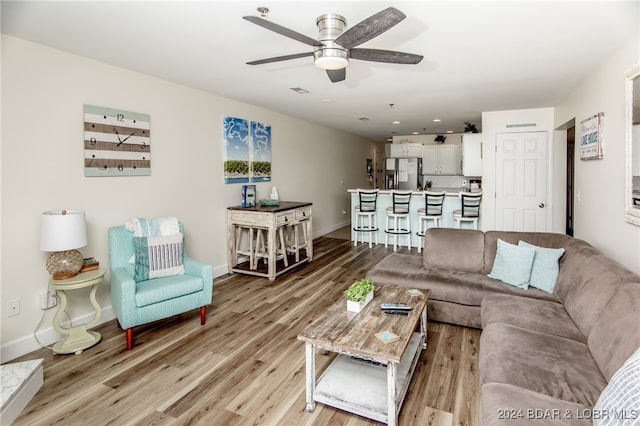 living room with light hardwood / wood-style flooring and ceiling fan