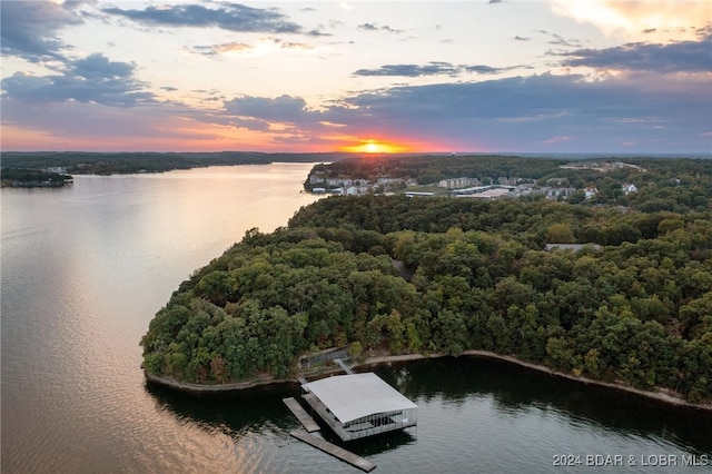 aerial view at dusk featuring a water view