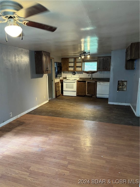 kitchen with dark brown cabinetry, white appliances, ceiling fan, and dark wood-type flooring