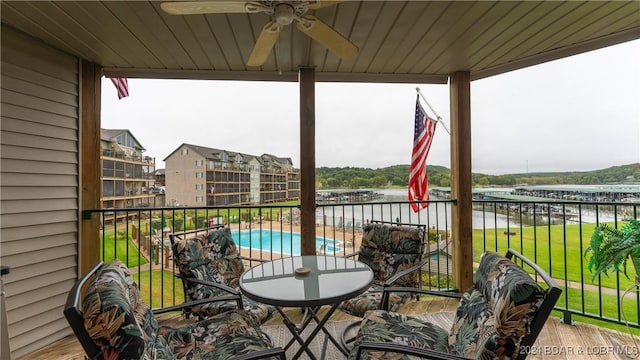 balcony with ceiling fan and a water view