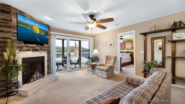 living room with a premium fireplace, ceiling fan, and light colored carpet