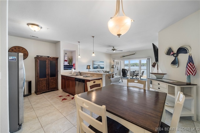 dining space featuring light tile patterned floors, sink, and ceiling fan