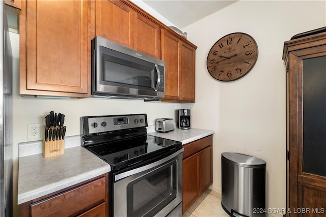 kitchen with light tile patterned floors and stainless steel appliances