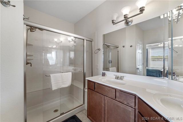 bathroom featuring tile patterned flooring, vanity, and a shower with shower door