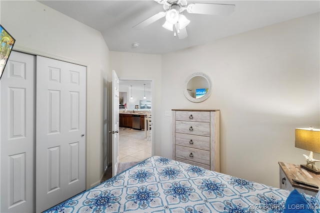 bedroom featuring light tile patterned floors, ceiling fan, and a closet