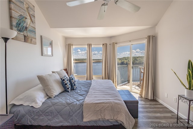 bedroom featuring access to outside, ceiling fan, dark hardwood / wood-style flooring, and a water view