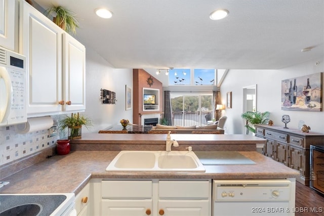 kitchen with dark hardwood / wood-style floors, sink, white cabinets, backsplash, and white appliances