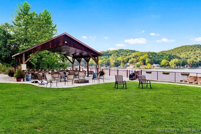 view of home's community featuring a mountain view, a patio area, and a yard