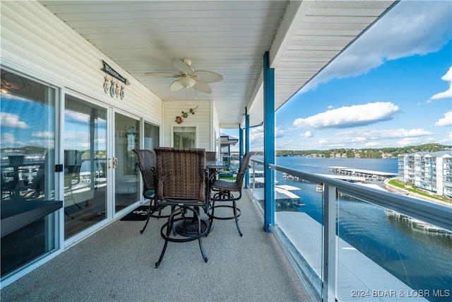 balcony featuring a water view and ceiling fan