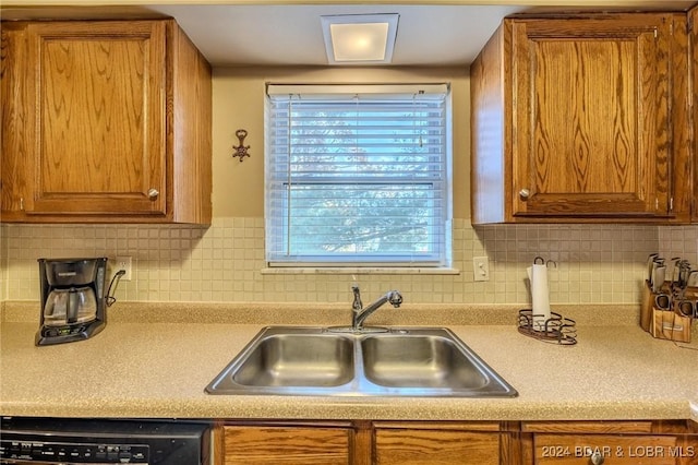 kitchen featuring backsplash, dishwasher, and sink