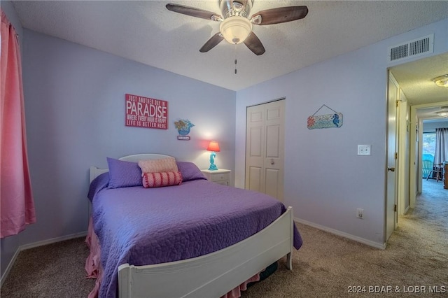 carpeted bedroom featuring a textured ceiling, a closet, and ceiling fan