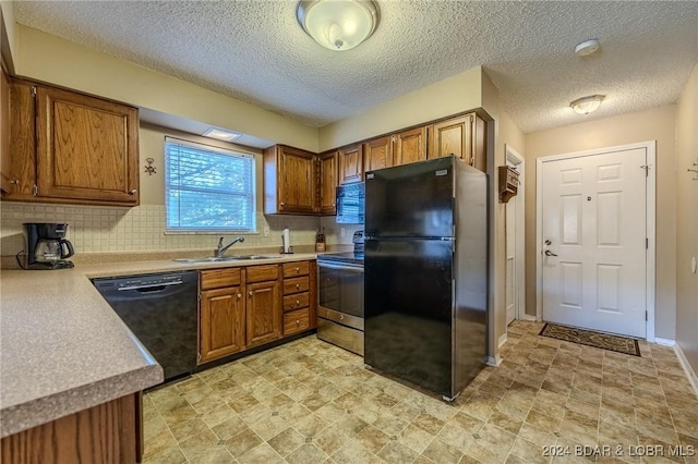 kitchen with backsplash, sink, black appliances, and a textured ceiling