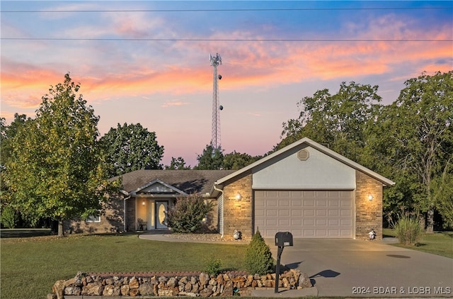 single story home featuring a lawn and a garage