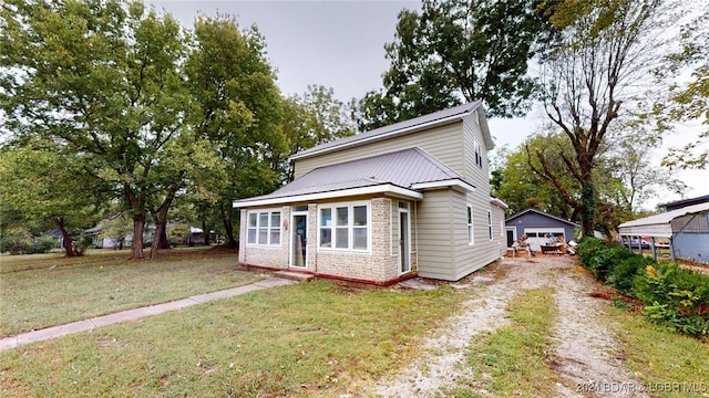 view of front facade featuring a garage, an outbuilding, and a front yard