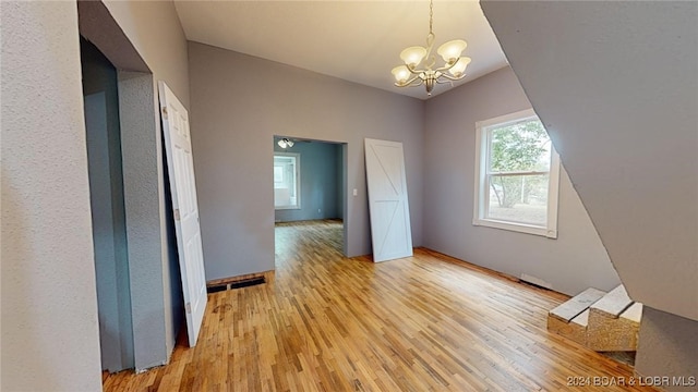 interior space featuring light hardwood / wood-style floors and an inviting chandelier