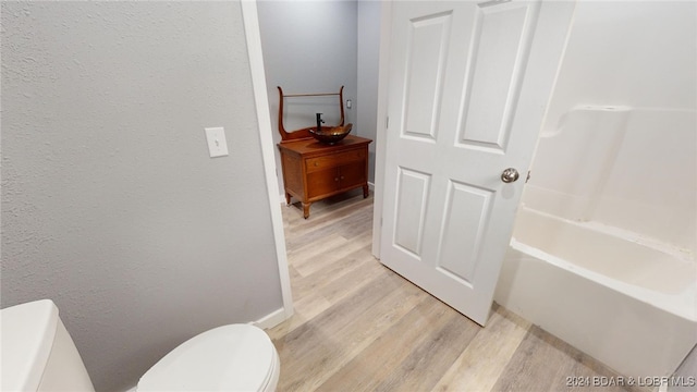 bathroom with toilet and hardwood / wood-style flooring