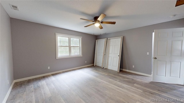 unfurnished bedroom with ceiling fan, light hardwood / wood-style floors, and a textured ceiling