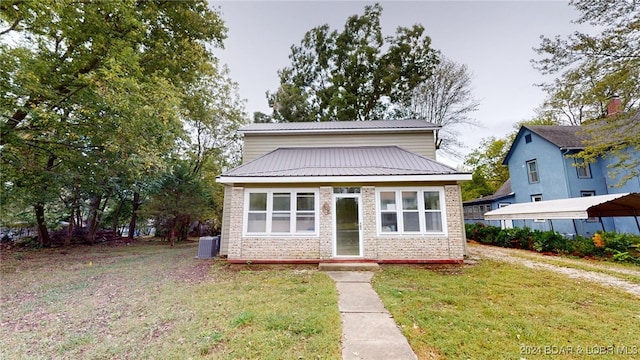 view of front of property with central AC unit and a front yard